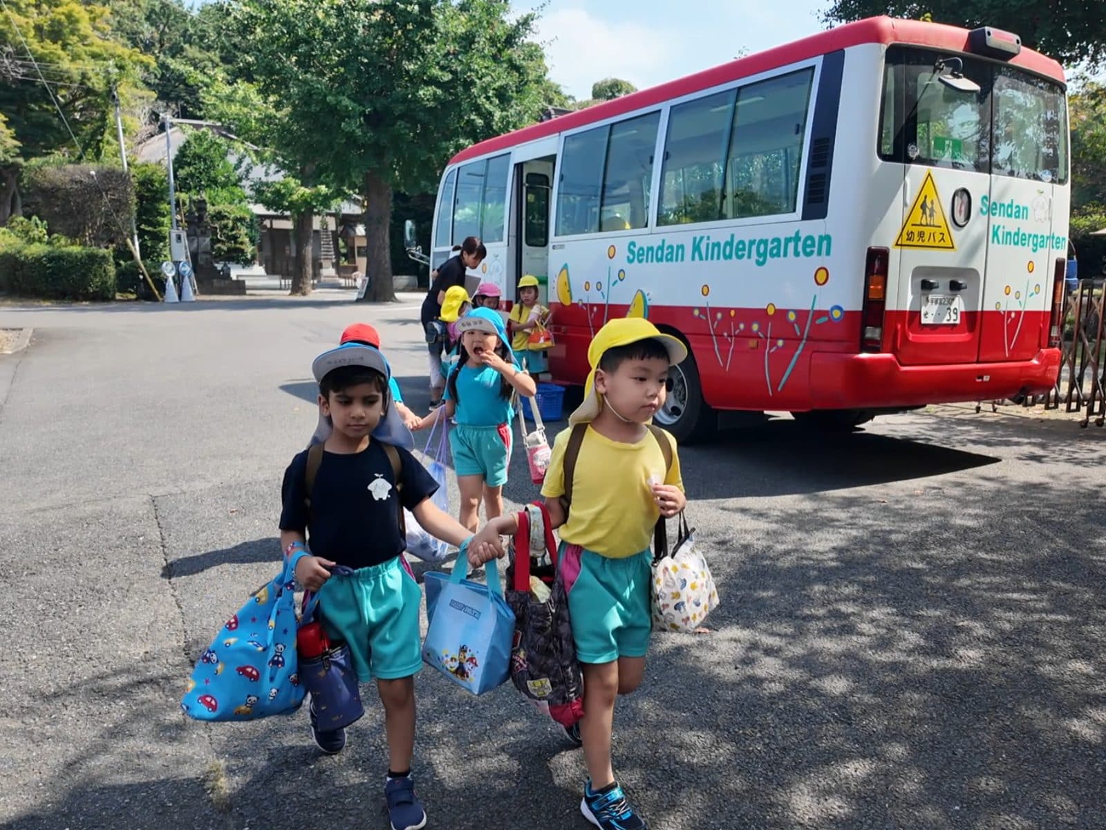 園バスから降りて登園する子どもたち