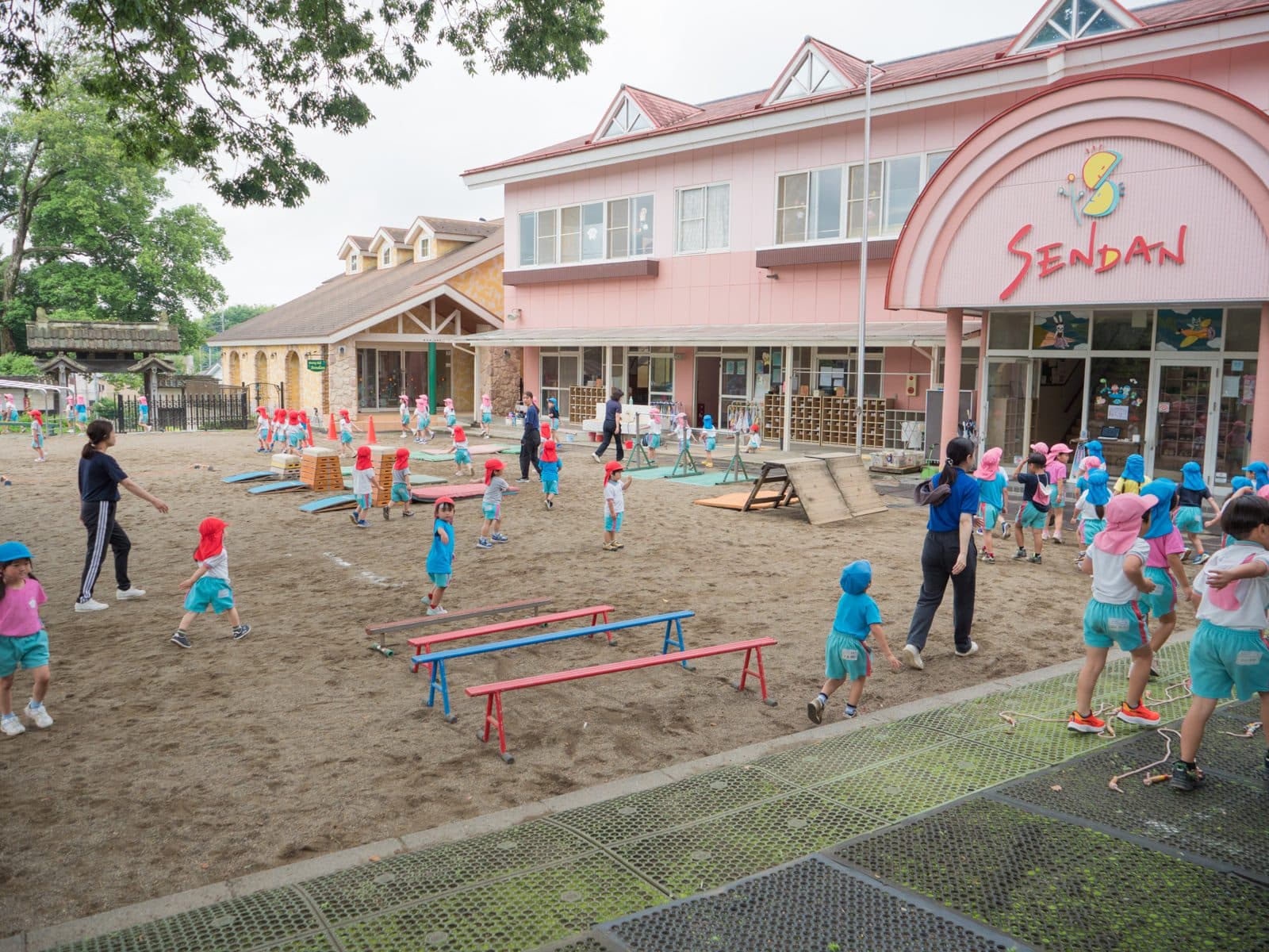 園庭いっぱいに組まれた運動ローテーションのコースと子どもたち